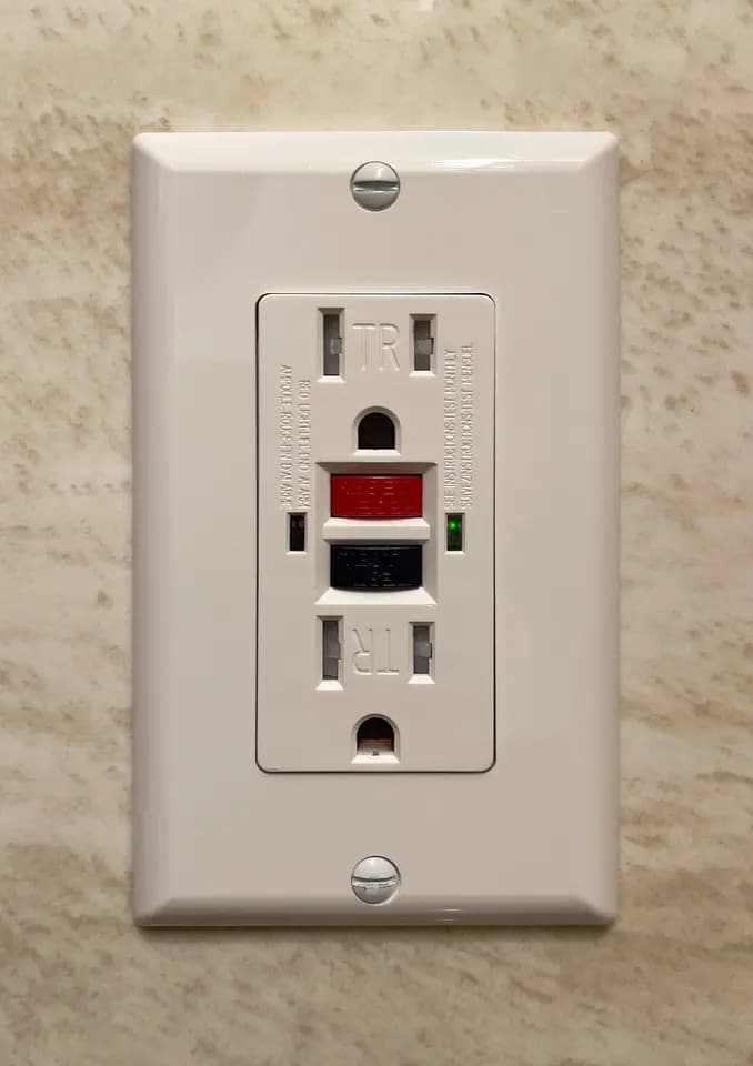 A residential GFCI electrical receptacle with test and reset buttons
