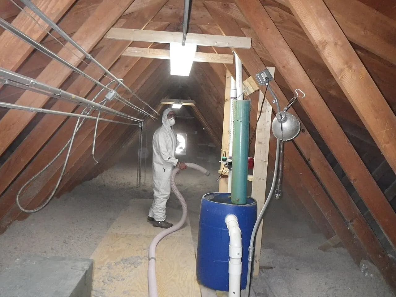 A worker placing insulation in an attic